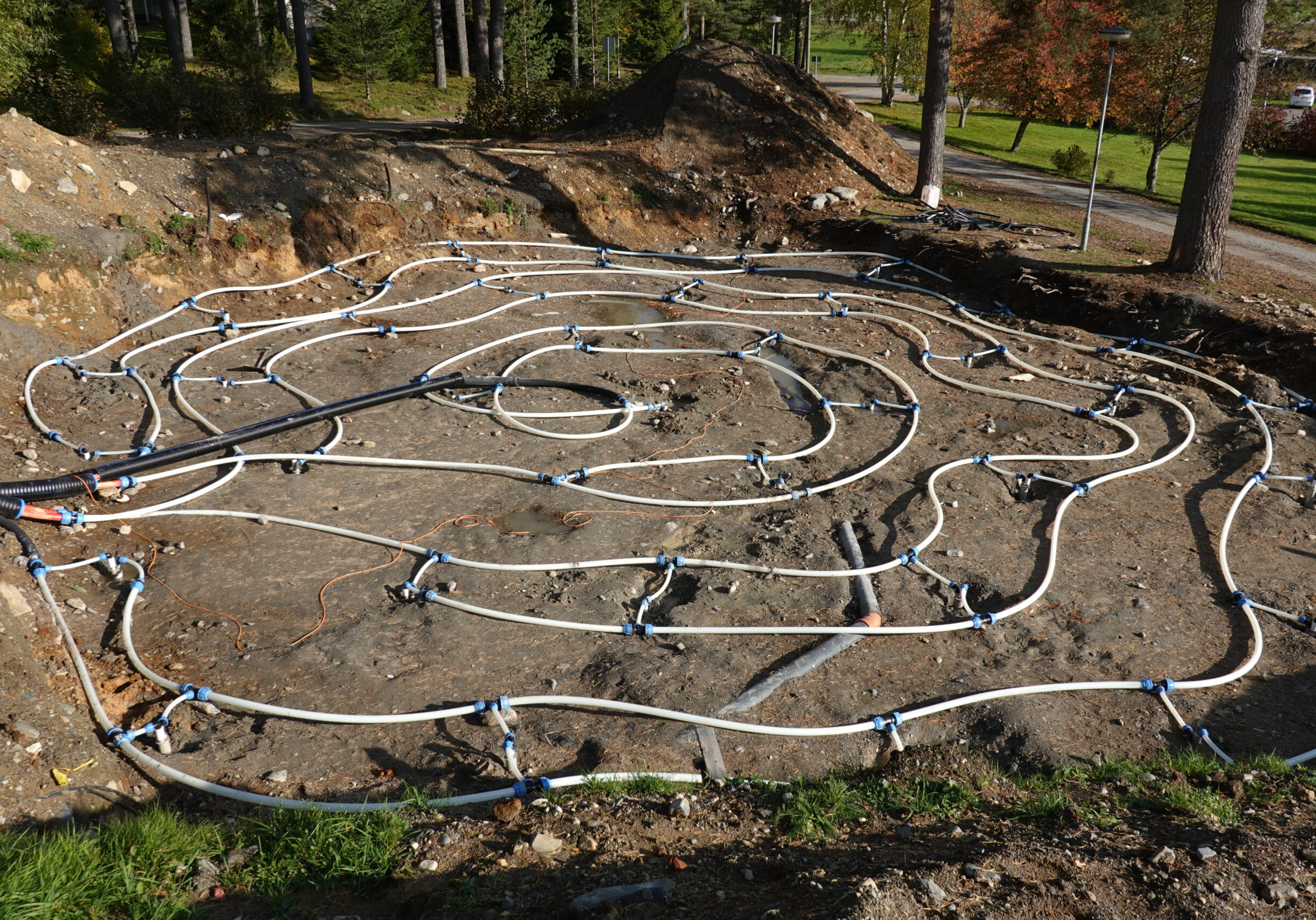 Lämmön kausivaraston asennusvaihe. Maahan kaivettu spiraalinmuotoinen putkisto, joka toimii lämpöakkuna varastoiden energiaa maaperään.