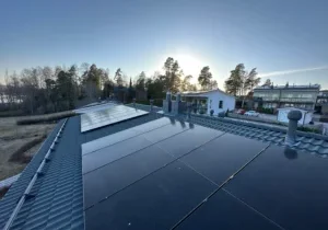 Mustat aurinkopaneelit asennettuna rivitalojen katolla